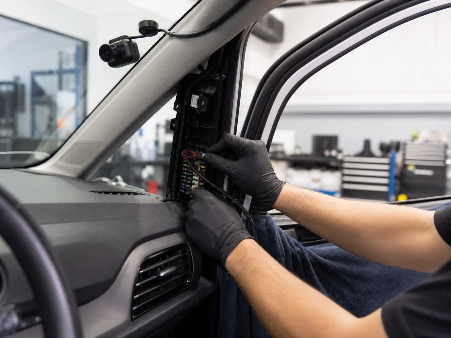 Auto electrician professionally hardwiring a dash cam